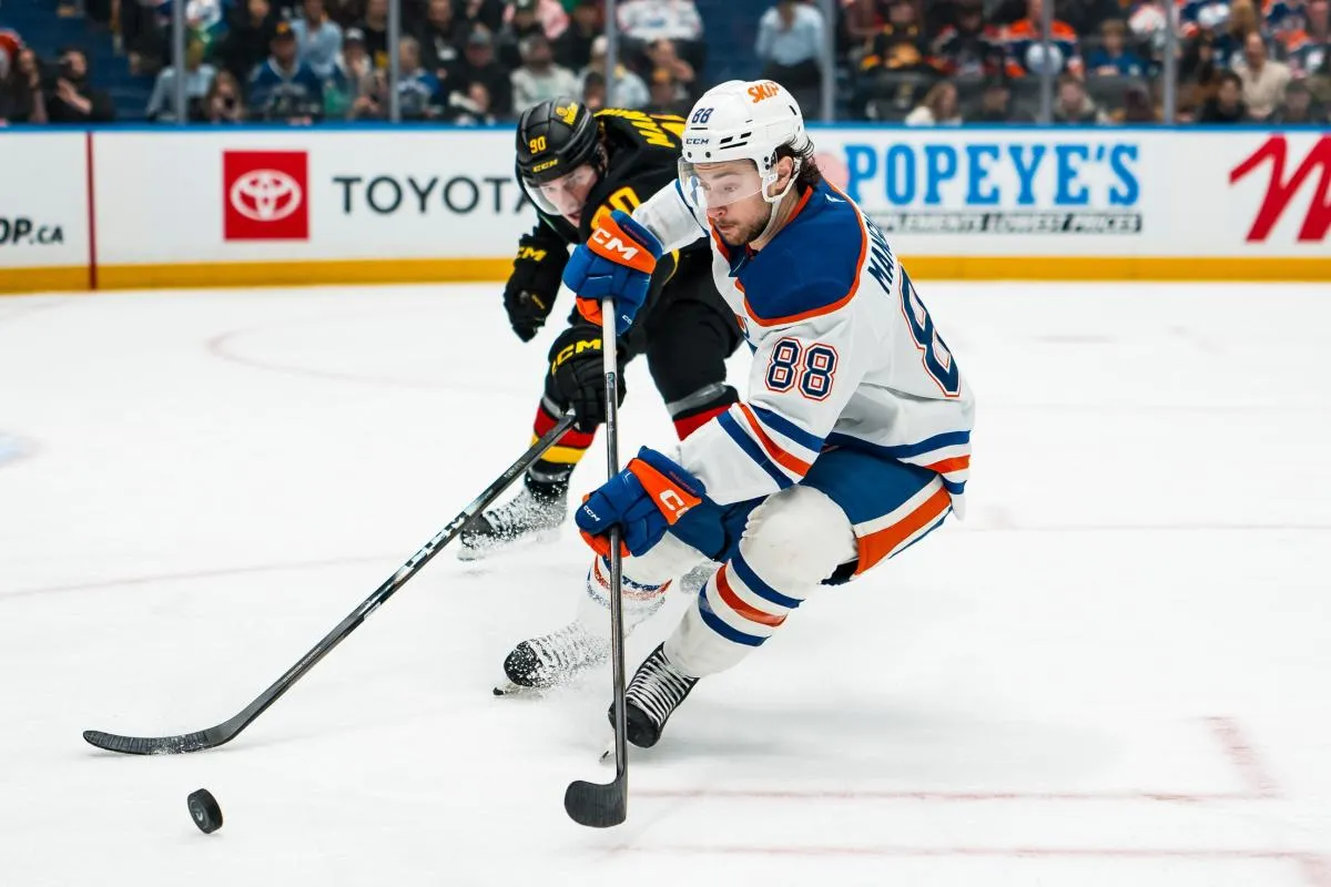 Vancouver Canucks defenseman Victor Mancini (90) stick checks Edmonton Oilers forward Andrew Mangiapane (88) in the third period at Rogers Arena.