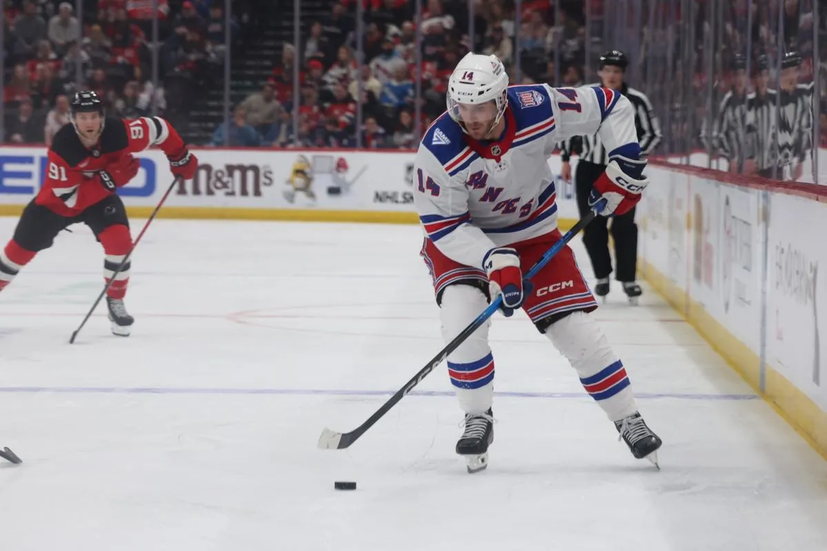 New York Rangers right wing Taylor Raddysh (14) moves the puck up ice against the New Jersey Devils during the third period at Prudential Center.