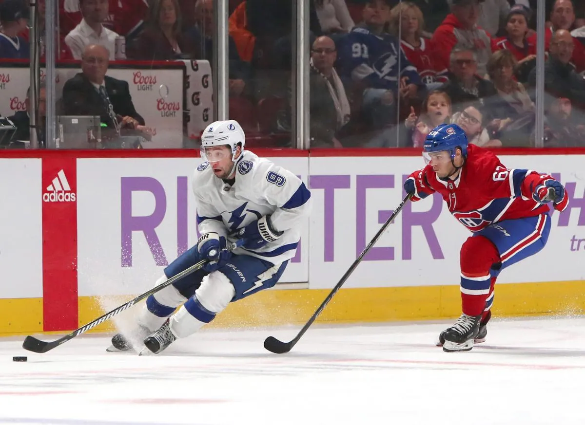 Tampa Bay Lightning center Tyler Johnson (9) plays the puck Montreal Canadiens center Matthew Peca (63) during the third period at Bell Centre.