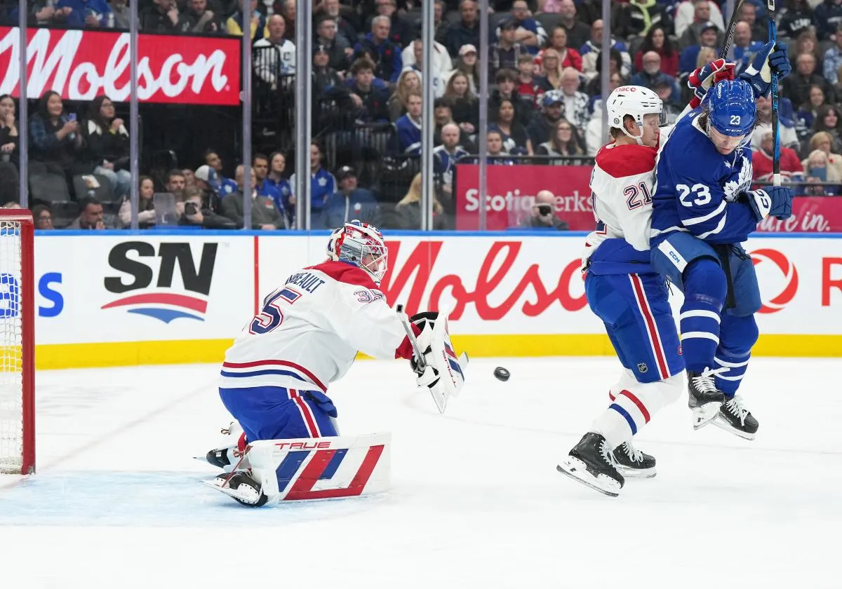 L'ailier gauche des Maple Leafs de Toronto, Matthew Knies (23), se bat pour la rondelle avec le d&eacute;fenseur des Canadiens de Montr&eacute;al, Kaiden Guhle (21), devant le gardien de but Sam Montembeault (35) pendant la premi&egrave;re p&eacute;riode au Scotiabank Arena.
