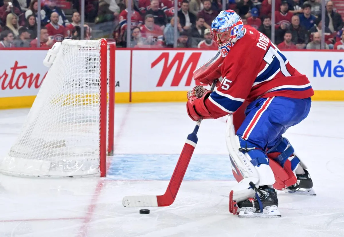 Le gardien des Canadiens de Montr&eacute;al, Jakub Dobes (75), s'empare du palet au cours de la troisi&egrave;me p&eacute;riode du match contre les Maple Leafs de Toronto au Centre Bell.