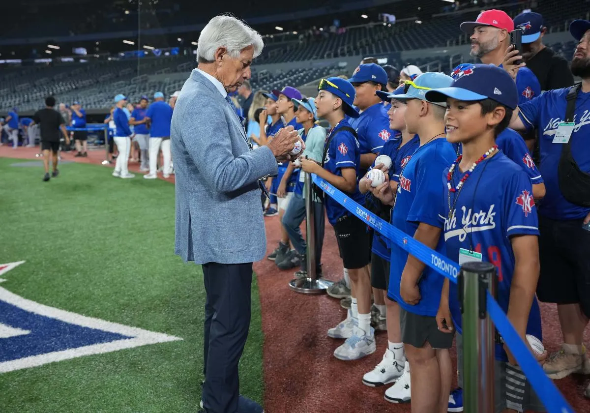Toronto Blue Jays color commentator Buck Martinez signs autographs during batting practice before a game against the Chicago Cubs at Rogers Centre.