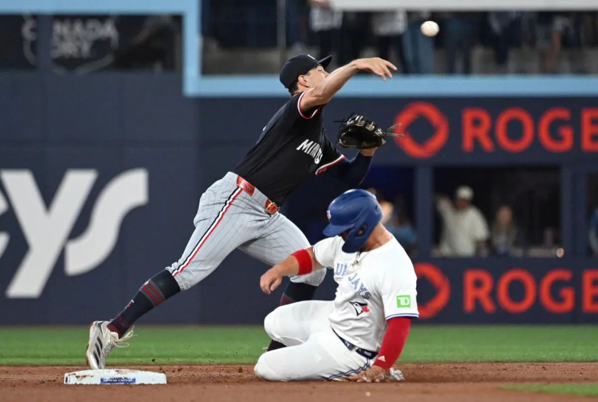 Minnesota Twins shortstop Brooks Lee (2) throws to first base for a double play after forcing out Toronto Blue Jays first baseman Ty France (2) in the second inning at Rogers Centre