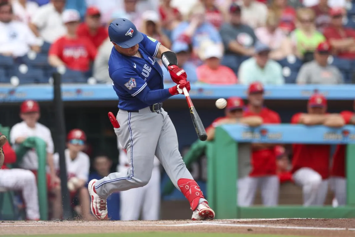 Toronto Blue Jays catcher Tyler Heineman (55) hits a home run against the Philadelphia Phillies in the first inning during spring training at BayCare Ballpark.