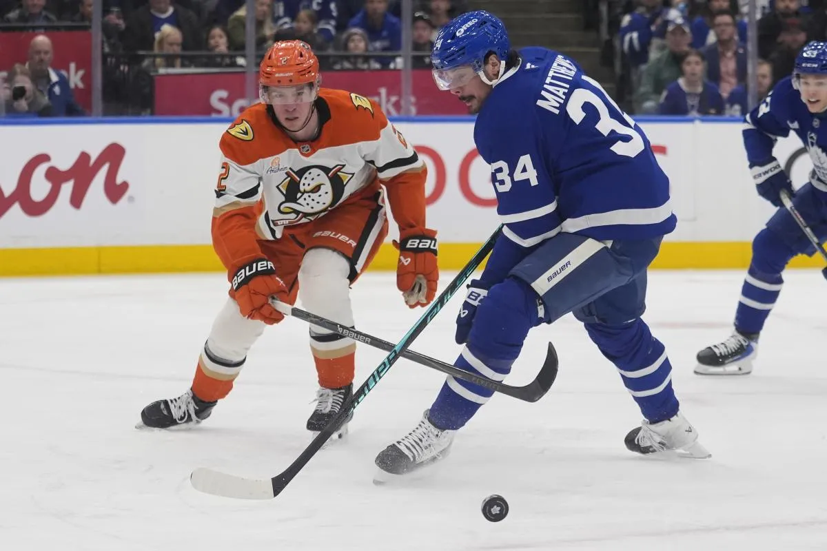 Anaheim Ducks defenseman Jackson LaCombe (2) knocks the puck away from Toronto Maple Leafs forward Auston Matthews (34) during the first period at Scotiabank Arena.