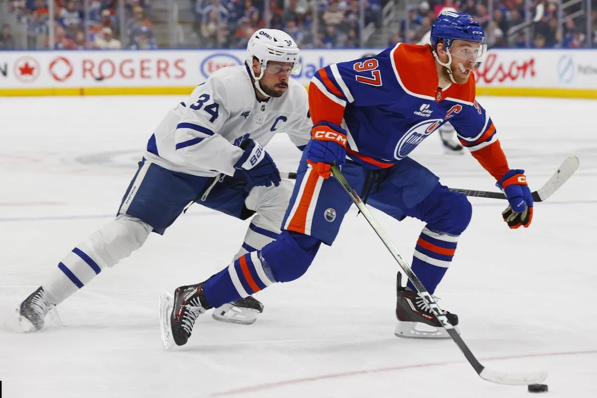 Edmonton Oilers forward Connor McDavid (97) carries the puck around Toronto Maple Leafs forward Auston Matthews (34) during the first period at Rogers Place.