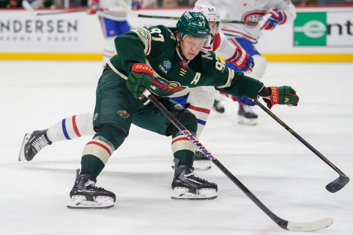 L'ailier gauche des Minnesota Wild, Kirill Kaprizov (97), est marqu&eacute; par le centre des Canadiens de Montr&eacute;al, Phillip Danault (24), lors de la prolongation au Grand Casino Arena.