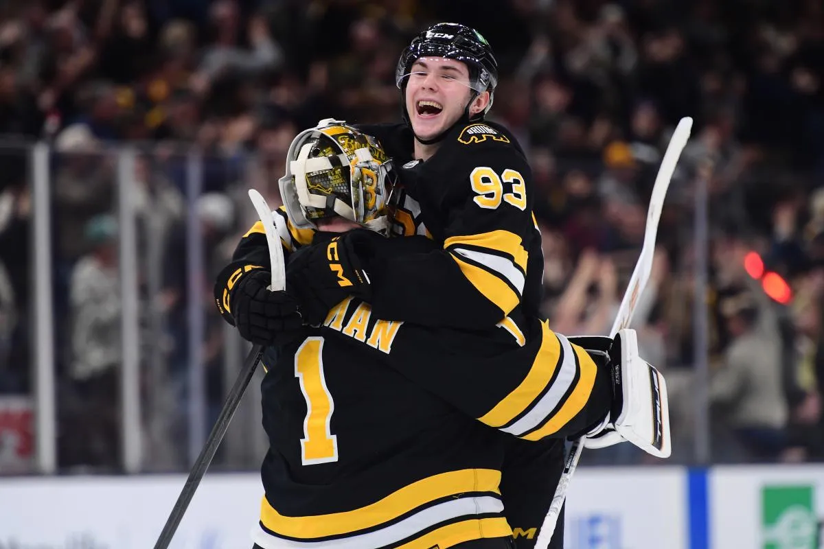 Boston Bruins center Fraser Minten (93) reacts with goaltender Jeremy Swayman (1) after defeating the Los Angeles Kings in overtime at TD Garden.