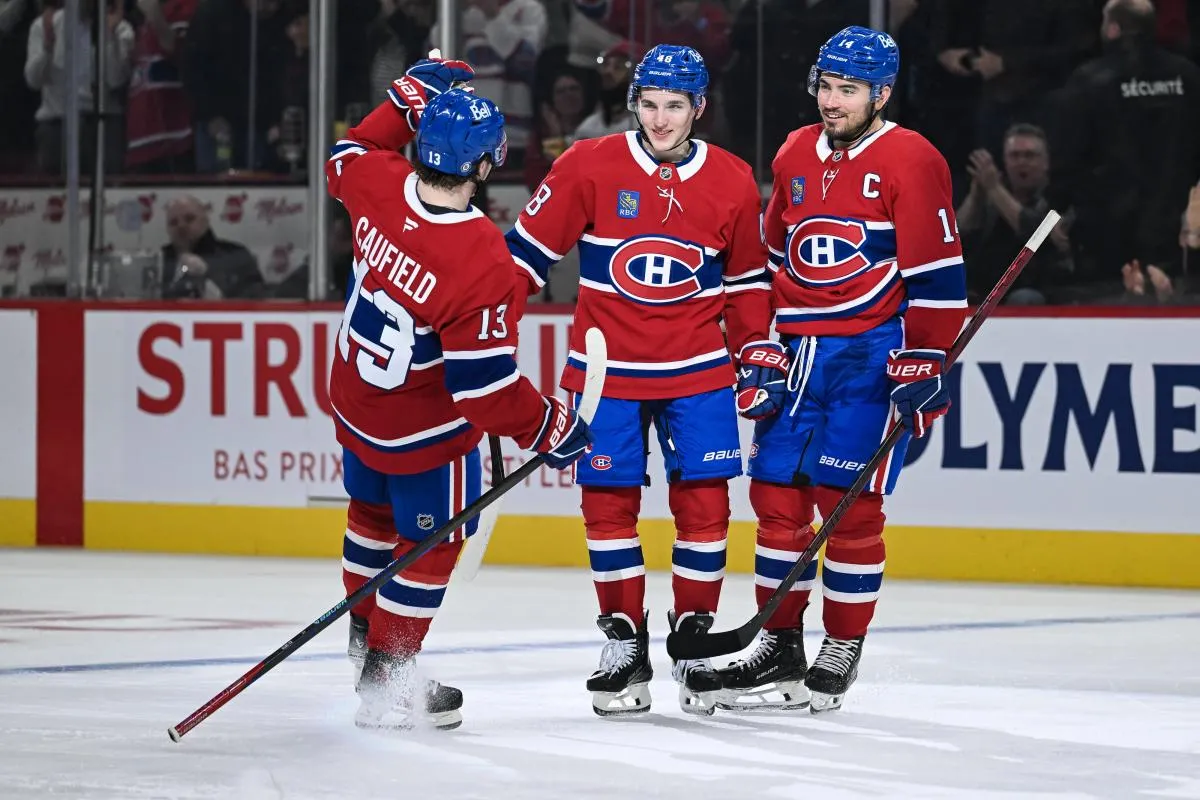 Le d&eacute;fenseur des Canadiens de Montr&eacute;al, Lane Hutson (48), c&eacute;l&egrave;bre avec l'ailier droit Cole Caufield (13) et le centre Nick Suzuki (14) son but marqu&eacute; contre les Hurricanes de la Caroline au cours de la troisi&egrave;me p&eacute;riode au Centre Bell.