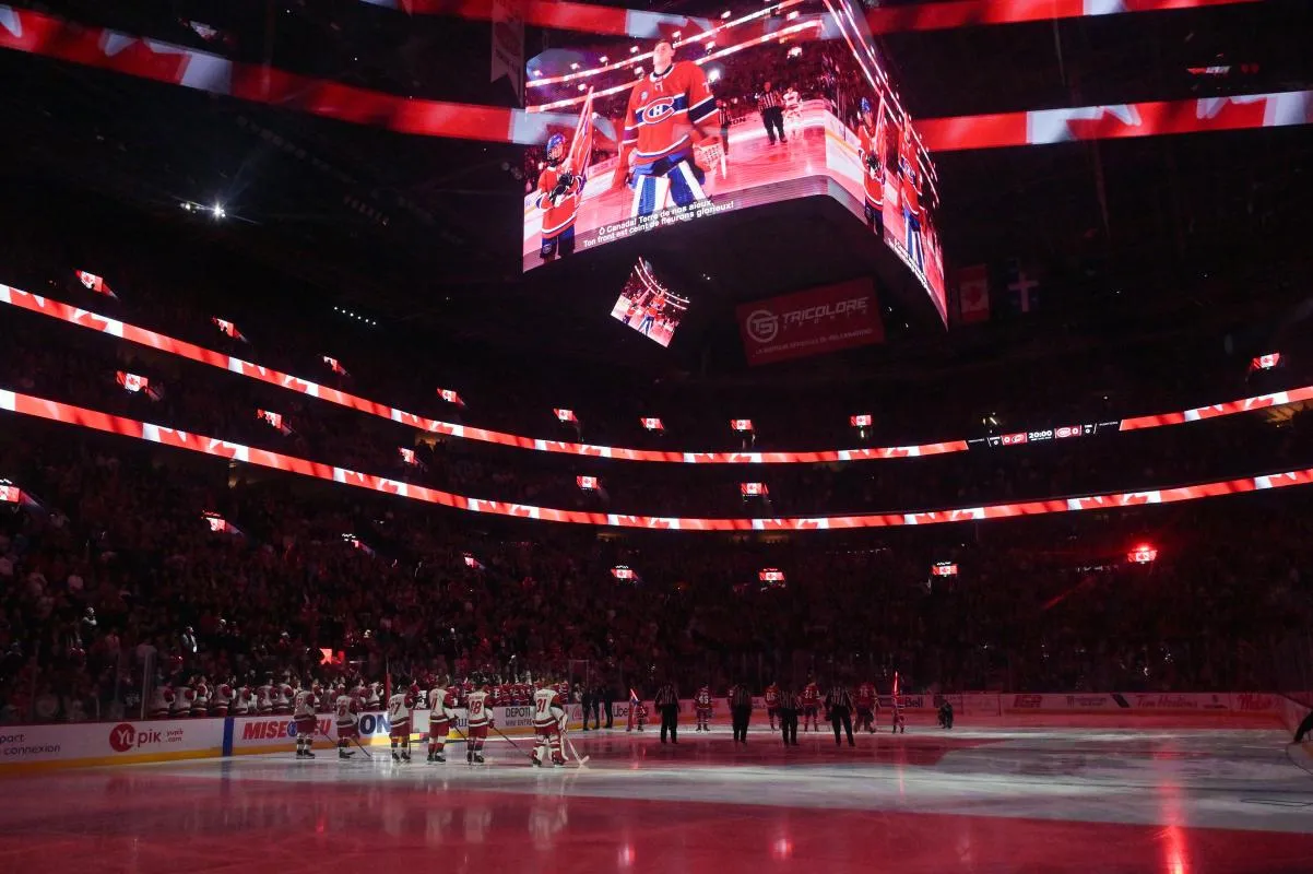 Les joueurs des Hurricanes de la Caroline et des Canadiens de Montr&eacute;al pendant l'hymne national au Centre Bell.