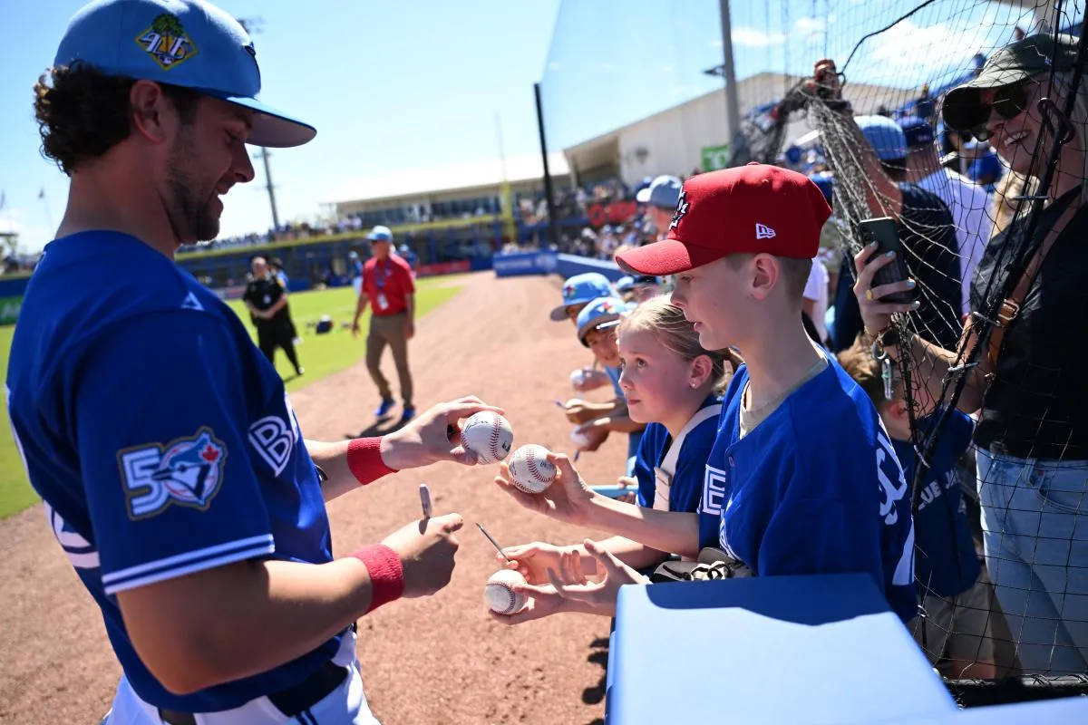 Toronto Blue Jays second baseman Ernie Clement (22) signs autographs before the start of the game against the Philadelphia Phillies during spring training at TD Ballpark.