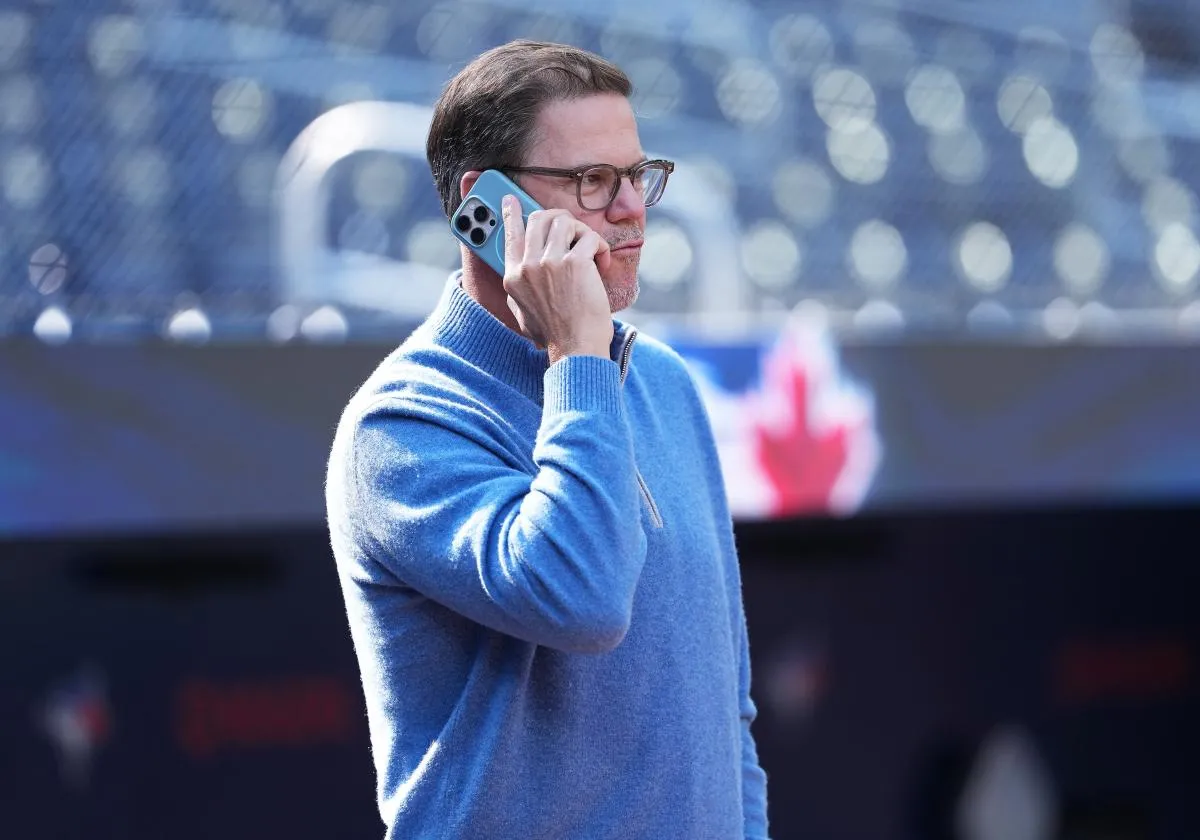 Toronto Blue Jays general manager Ross Atkins talks on the phone during batting practice before a game against the Baltimore Orioles at Rogers Centre.