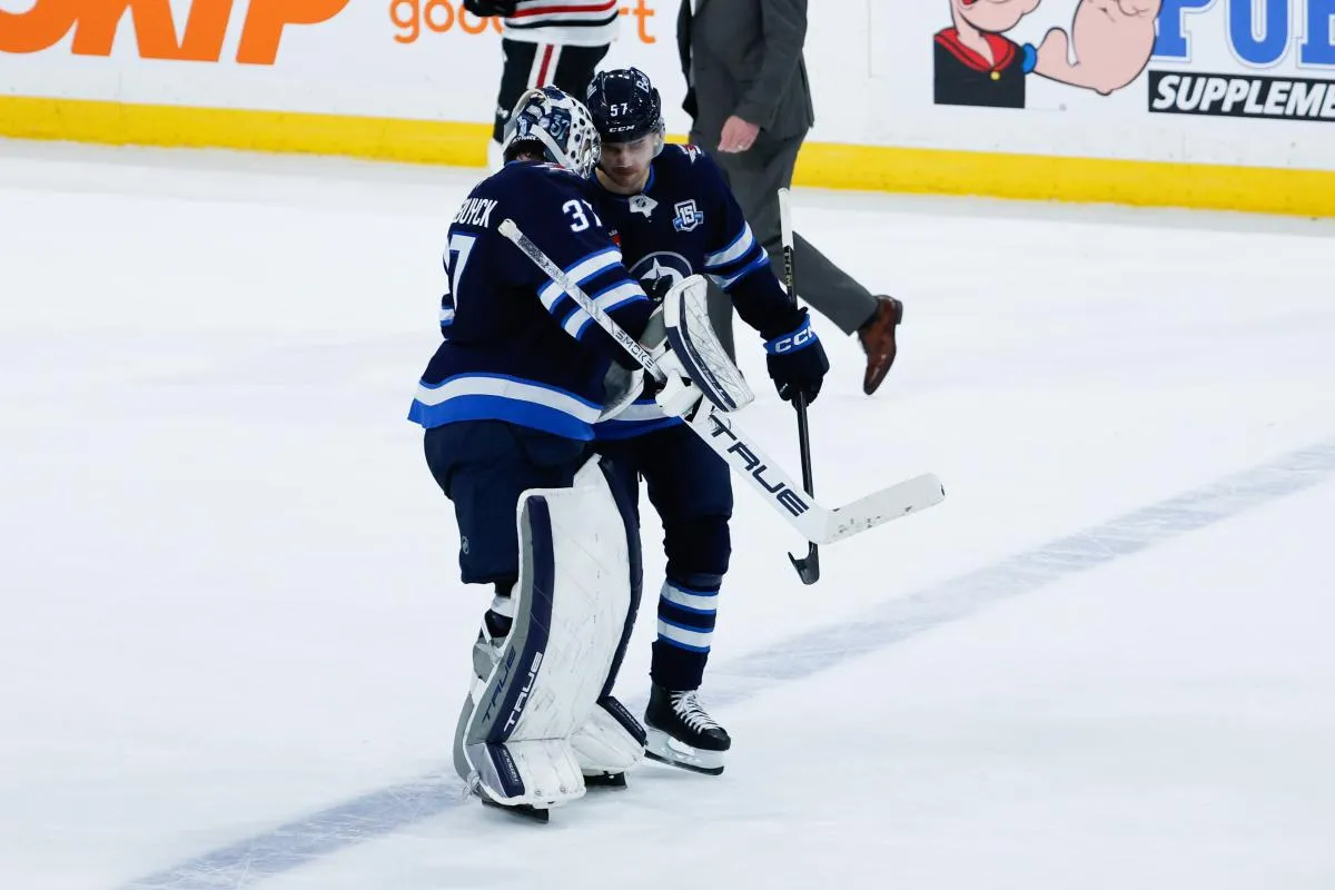 Winnipeg Jets goalie Connor Hellebuyck (37) is congratulated by defenseman Elias Salomonsson (57) after a win against the Chicago Blackhawks at Canada Life Centre.