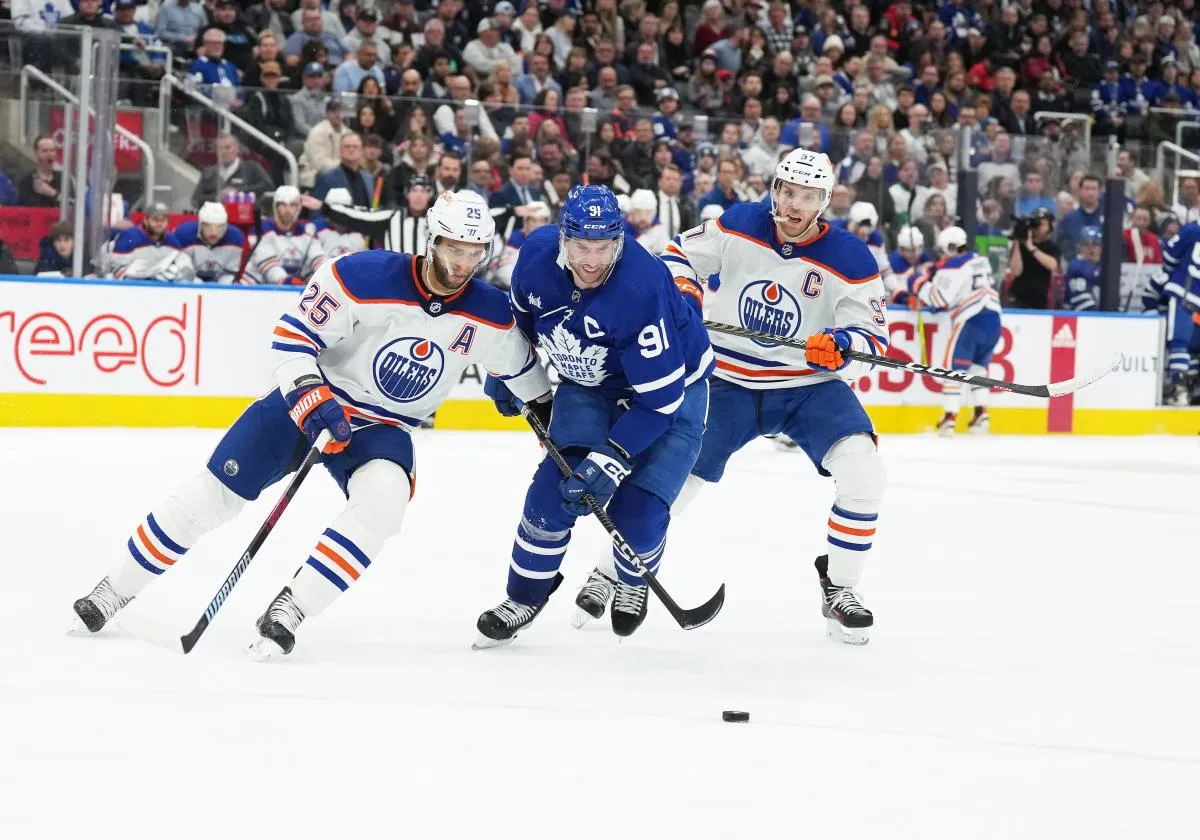 Toronto Maple Leafs center John Tavares (91) battles for the puck between Edmonton Oilers defenseman Darnell Nurse (25) and Edmonton Oilers center Connor McDavid (97) during the third period at Scotiabank Arena.