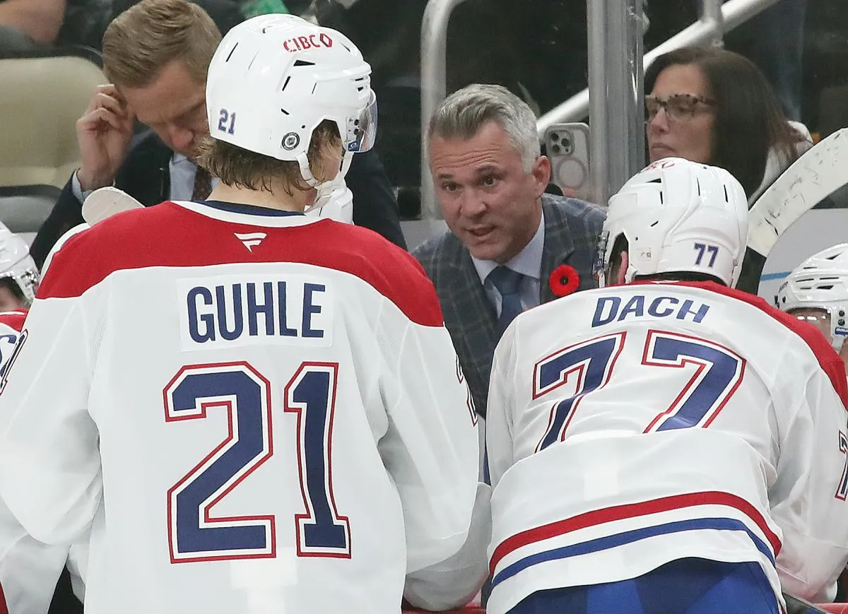 L'entraîneur-chef des Canadiens de Montréal, Martin St-Louis (à l'arrière), s'entretient avec le défenseur Kaiden Guhle (21) et le centre Kirby Dach (77) sur le banc lors du match contre les Penguins de Pittsburgh, au cours de la troisième période, au PPG Paints Arena.