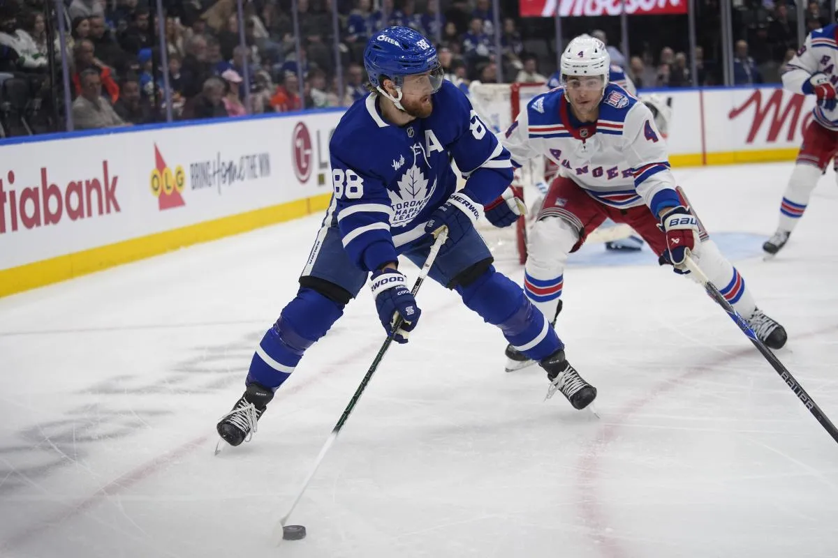 Toronto Maple Leafs forward William Nylander (88) goes to pass the puck as New York Rangers defenseman Braden Schneider (4) closes in during the third period at Scotiabank Arena.