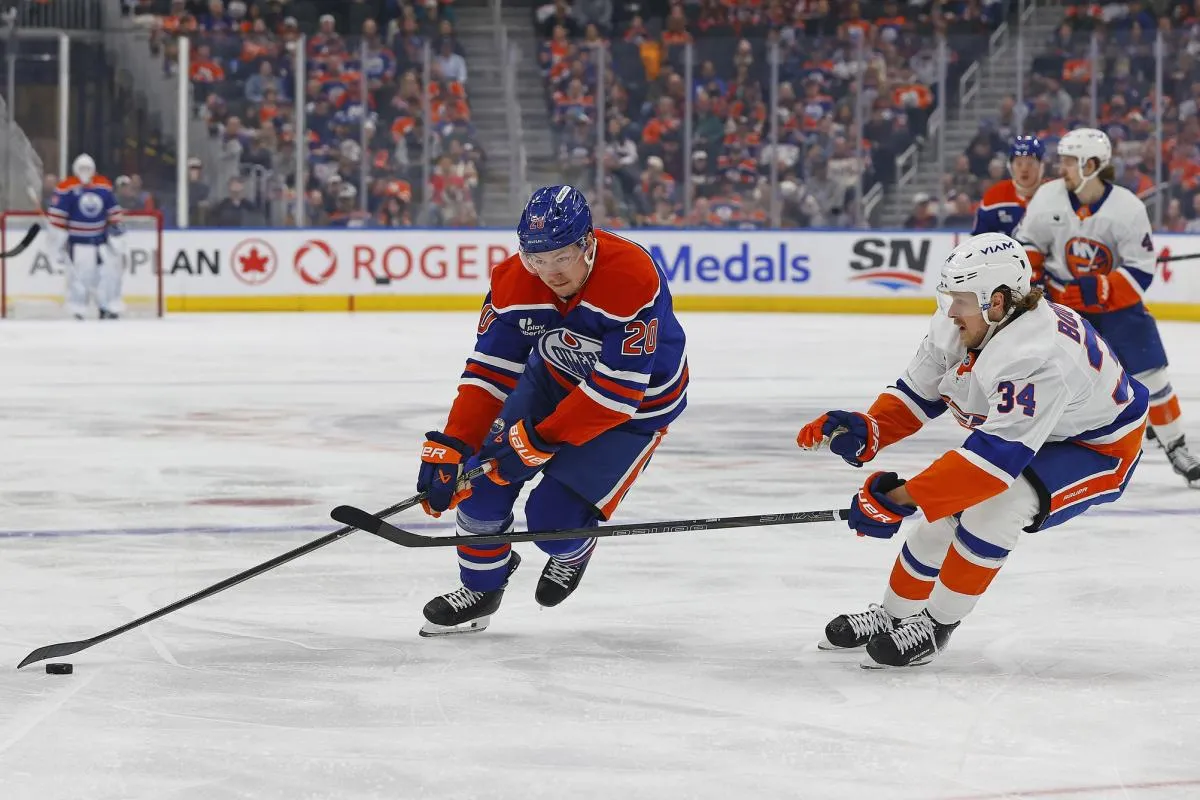 Edmonton Oilers forward Curtis Lazar (20) controls the puck around New York Islanders defensemen Adam Boqvist (34) during the first period at Rogers Place.