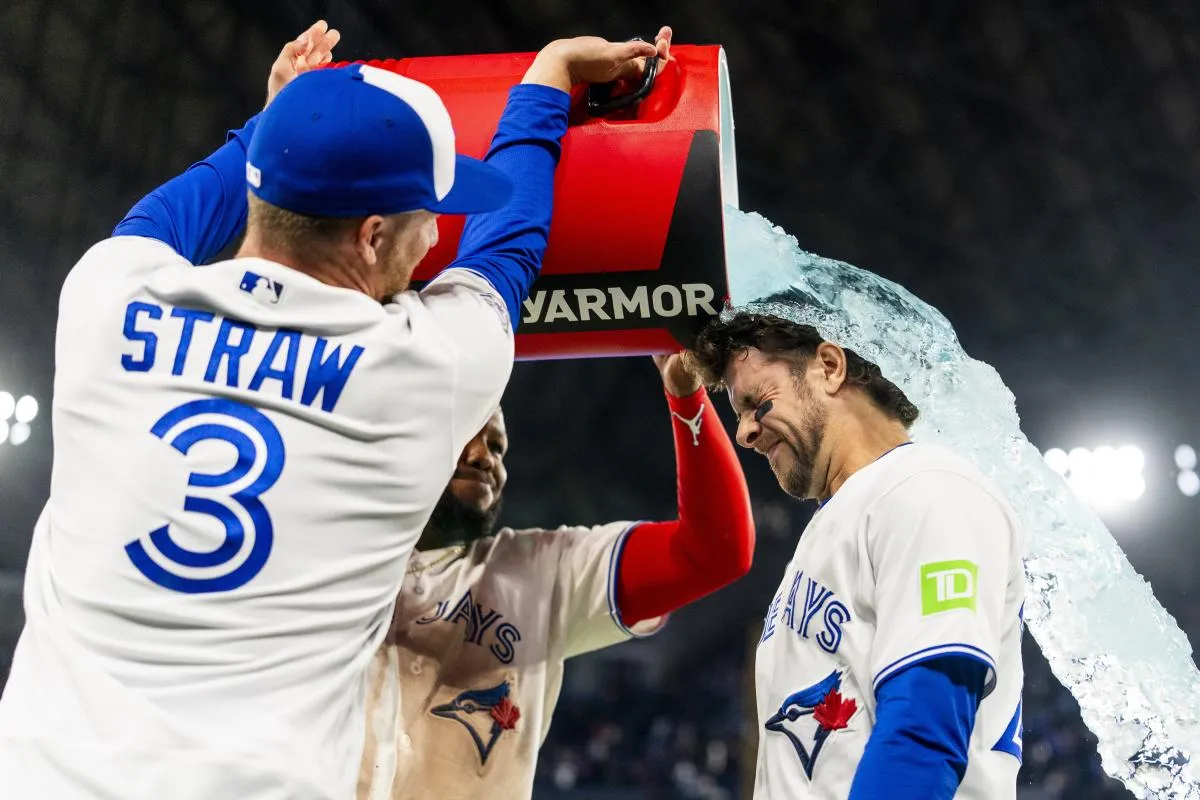 Toronto Blue Jays first baseman Vladimir Guerrero Jr. (27) and center fielder Myles Straw (3) pour a sports drink on third baseman Ernie Clement (22) after defeating the Athletics at Rogers Centre.