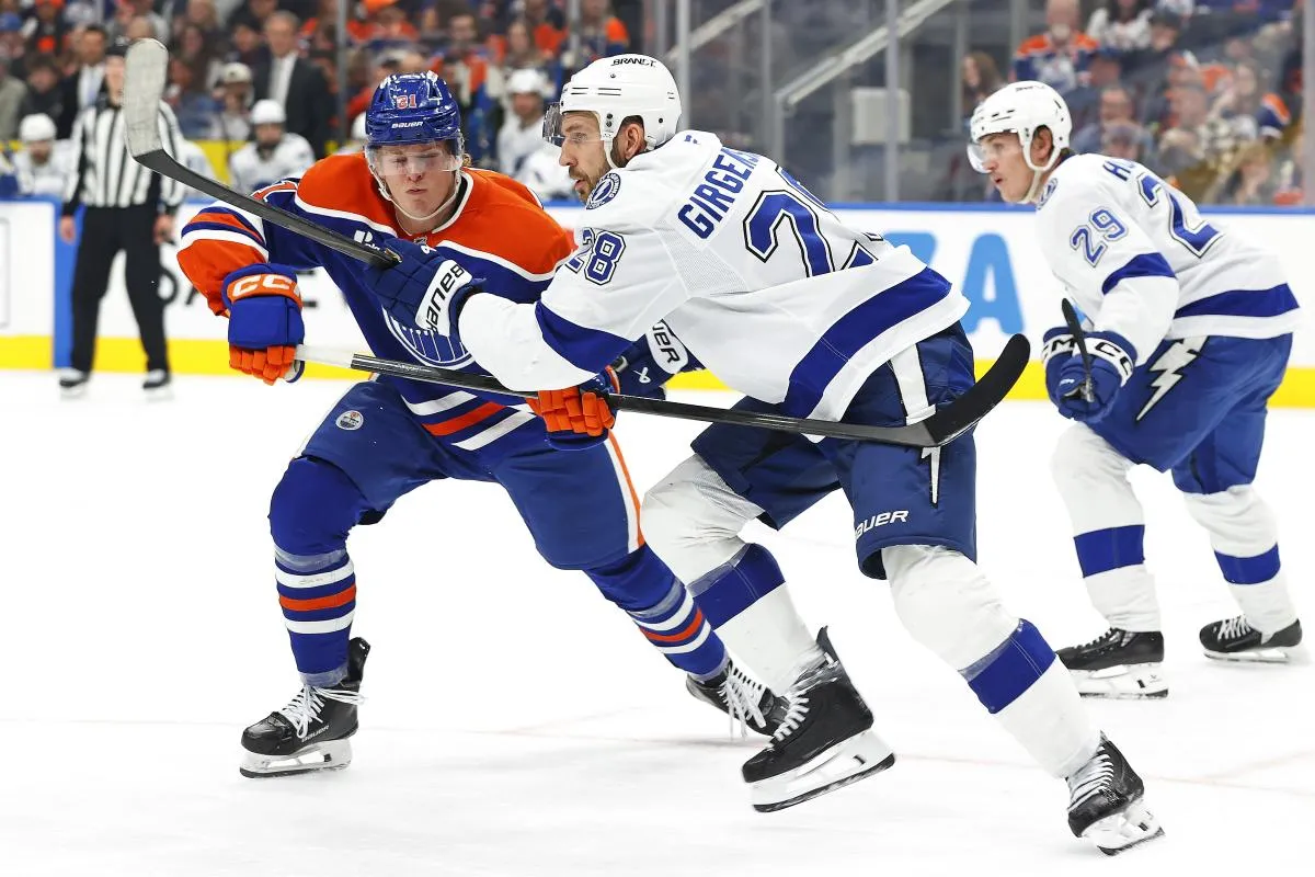 Edmonton Oilers forward Josh Samanski (81) and Tampa Bay Lightning forward Zemgus Girgensons (28) chase a loose puck during the third period at Rogers Place.