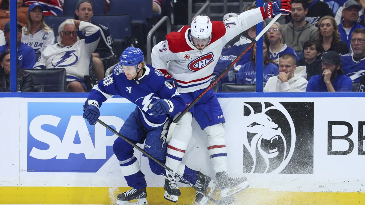 Tampa Bay Lightning defenseman J.J. Moser (90) and Montreal Canadiens center Kirby Dach (77) battle for the puck in the third period during game two of the first round of the 2026 Stanley Cup Playoffs at Benchmark International Arena.