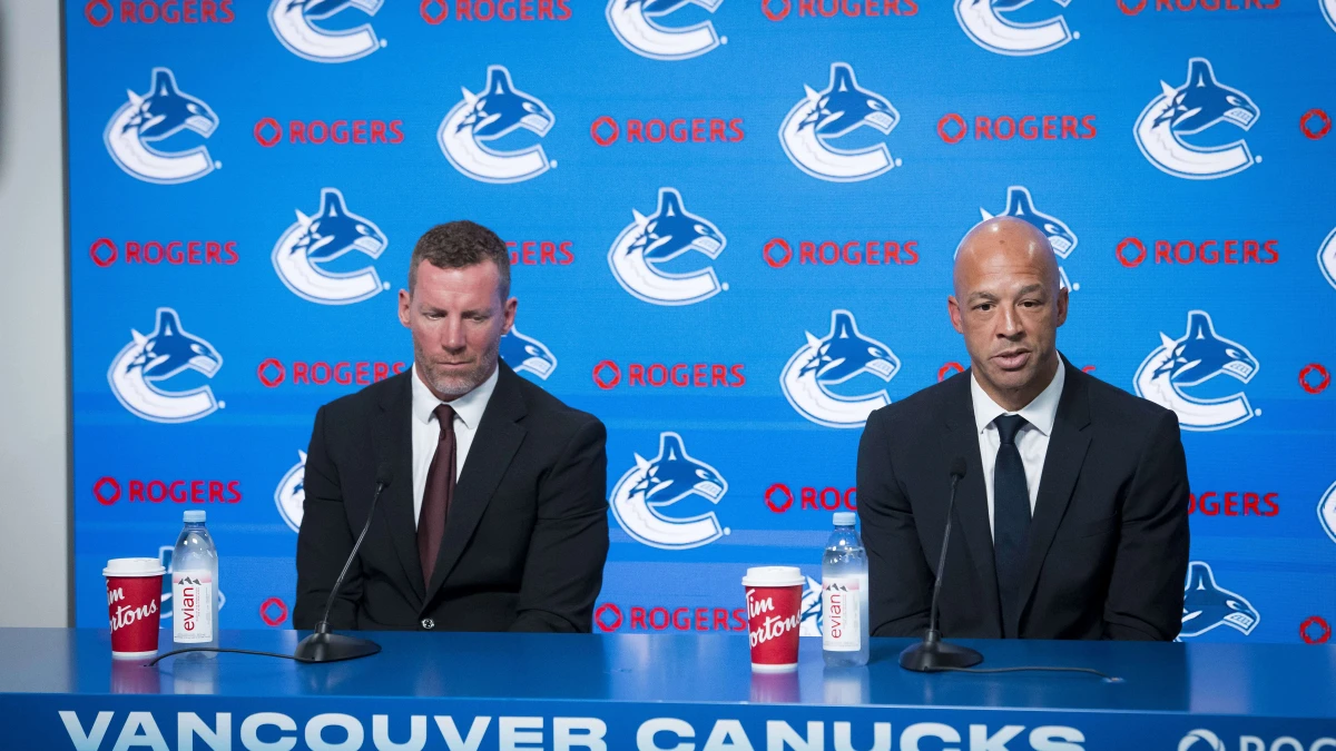 General manager Ryan Johnson listens to Manny Malhotra speak during press conference where the Vancouver Canucks introduce Malhotra as their new head coach during a press conference at Rogers Arena.