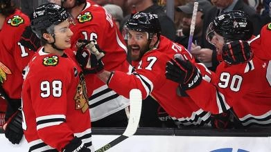 Chicago Blackhawks rookie Connor Bedard celebrating a goal by fist-bumping veteran forward