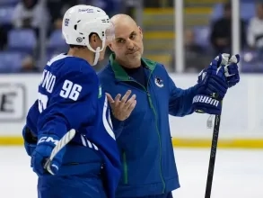 Tocchet and Kuzmenko talking during practice.