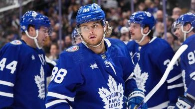 William Nylander breaks out of a huddle with Auston Matthews, John Tavares, and Morgan Rielly during a game.