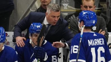 Sheldon Keefe giving Mitch Marner a talk from the bench during a Toronto Maple Leafs Game.