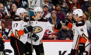Anaheim Ducks players Alex Killorn, Leo Carlsson and Cam Fowler celebrating a goal.