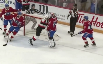 Brennan Saulnier of the Belleville Senators shoves Laval Rockets goaltender Kasimir Kaskisuo.