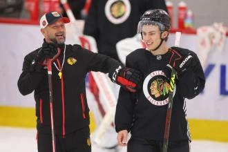 Connor Bedard and a coac during a practice with the Chicago Blackhawks