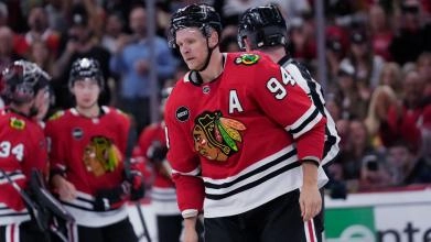 Former Chicago Blackhawks forward Corey Perry being escorted to the penalty box after a fight.