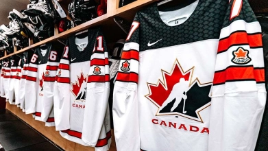 Team Canada Jerseys (White) hanging in a locker room prior to a game.