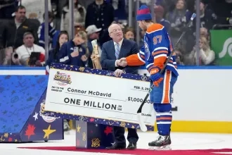 Connor McDavid receiving a cheque for 1 Million Dollars after winning the NHL All-Star Skills Competition.