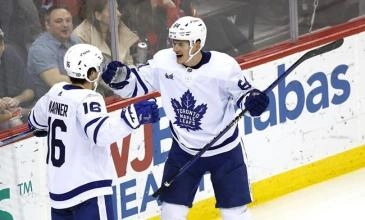 Toronto Maple Leafs forwards Mitch Marner (left) and David Kampf (right) celebrating a goal during an NHL game.