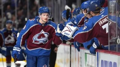 Cale Makar of the Colorado Avalanche skating past his bench after a goal during an NHL game.