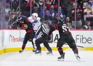Toronto Maple Leafs defenseman Morgan Rielly cross-checking Ridly Greig
