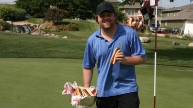 Phil Kessel on a golf course eating hot dogs out of the Stanley Cup.