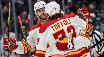 Calgary Flames defenseman Noah Hanifin celebrating a goal with forward Tyler Toffoli