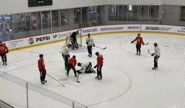 Chicago Blackhawks teammates surrounding injured defenseman Louis Crevier
