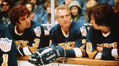 A picture from the hockey movie Slapshot, showing some of the hockey players on the bench