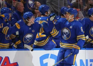 Buffalo Sabres defenseman Erik Johnson celebrating a goal with his teammates.