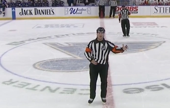 Garrett Rank, Official for the NHL, announcing a call during a game.
