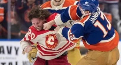 Calgary Flames forward Blake Coleman hitting Edmonton Oilers forward Connor McDavid hard into the boards.