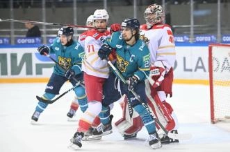 HK Sochi forwards Marat Khusnutdinov and Matvei Michkov fighting for position in front of the net against Kunlun Red Star in the KHL.