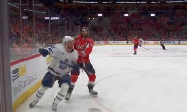 Washington Capitals' enforcer Tom Wilson giving a sitck hit on the face of Toronto Maple Leafs' player Noah Gregor during a game.