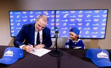 Mathieu Darche, assistant general manger of the Tampa Bay Lightning, with Tripp Nugent, signing a one-day contract with the team back in 2022.