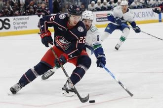 Jake Bean in action with the Columbus Blue Jackets against Conor Garland of the Vancouver Canucks.