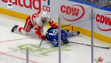 Toronto Maple Leafs defenseman Timothy Liljegren on the ice hurt after being hit into the boards by Detroit Red Wings forward Joe Veleno.